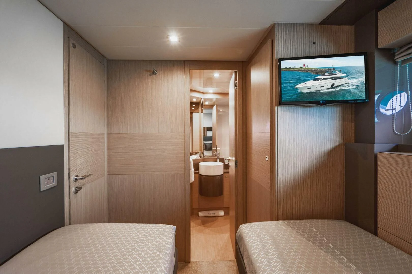 a bedroom with a bed and a television aboard KUDU Yacht for Sale