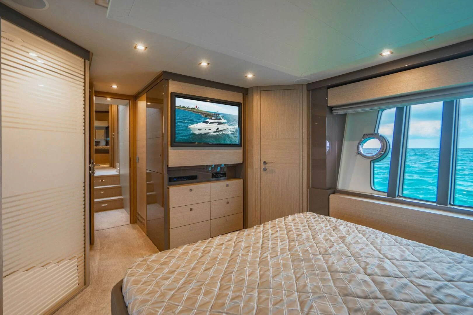 a bedroom with a bed and a tv on the wall aboard KUDU Yacht for Sale