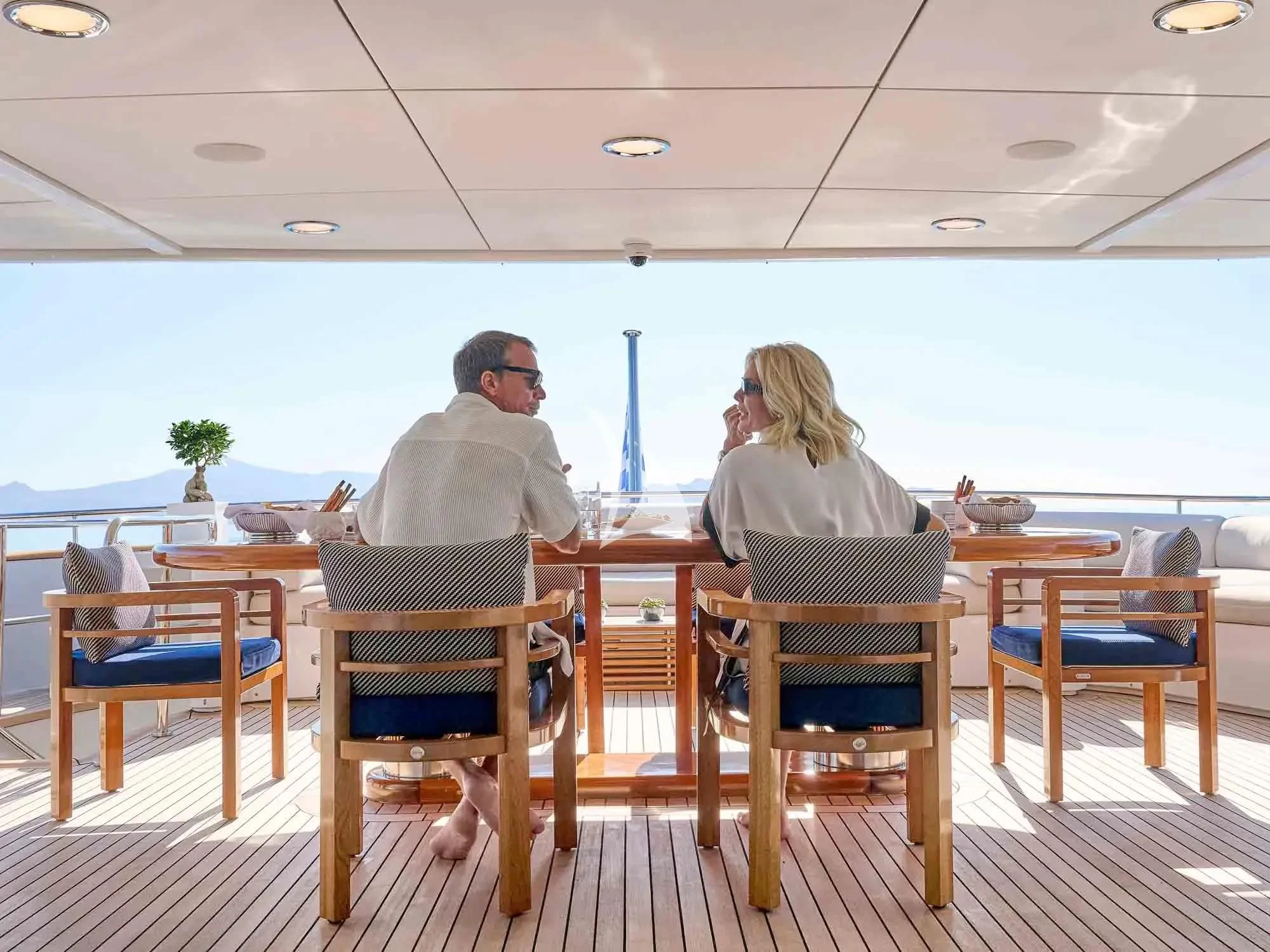 a man and woman sitting at a table aboard ARTEMISEA Yacht for Sale