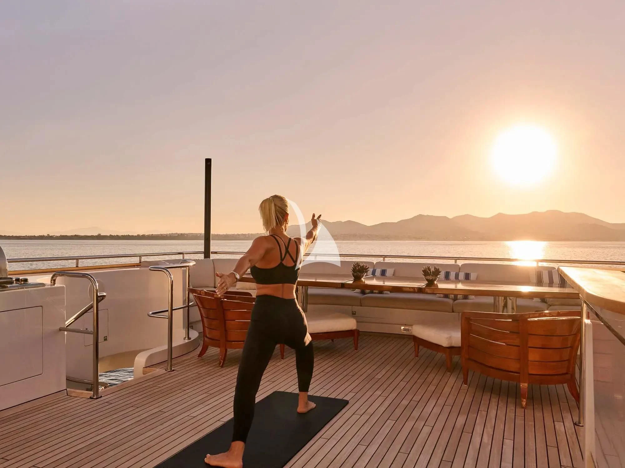 a person standing on a deck overlooking a sunset aboard ARTEMISEA Yacht for Sale