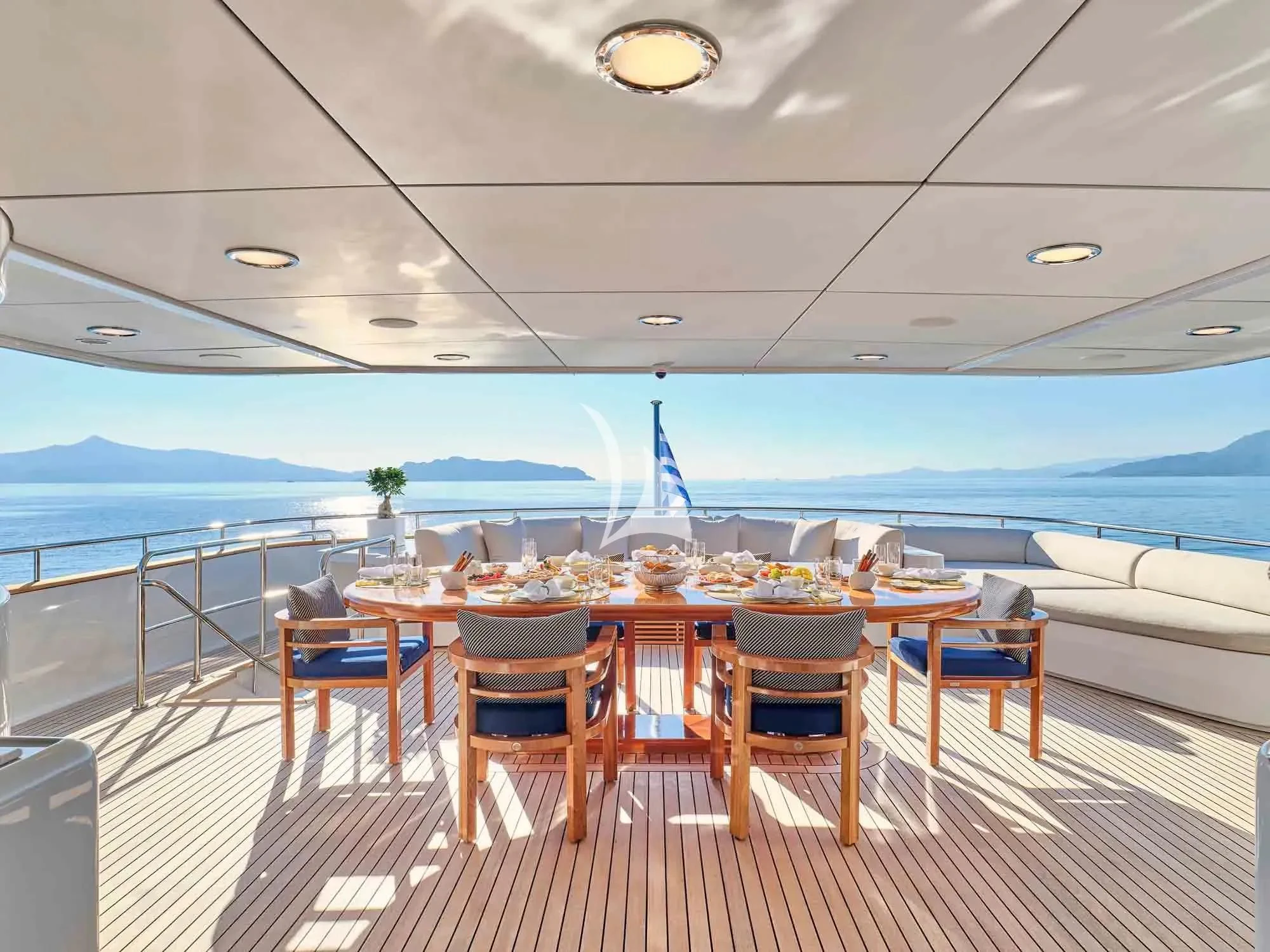 a table set for a meal on a deck overlooking the ocean aboard ARTEMISEA Yacht for Sale