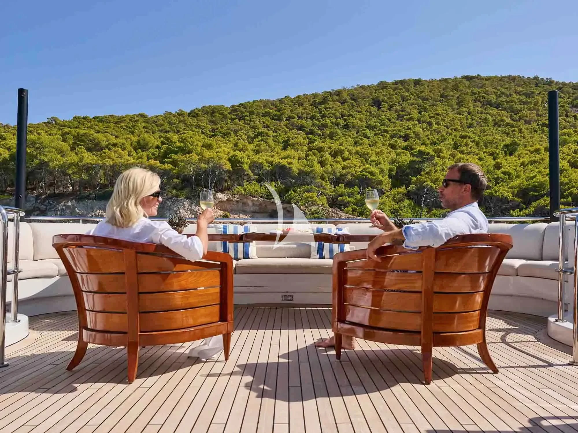 a man and woman sitting at a table outside aboard ARTEMISEA Yacht for Sale