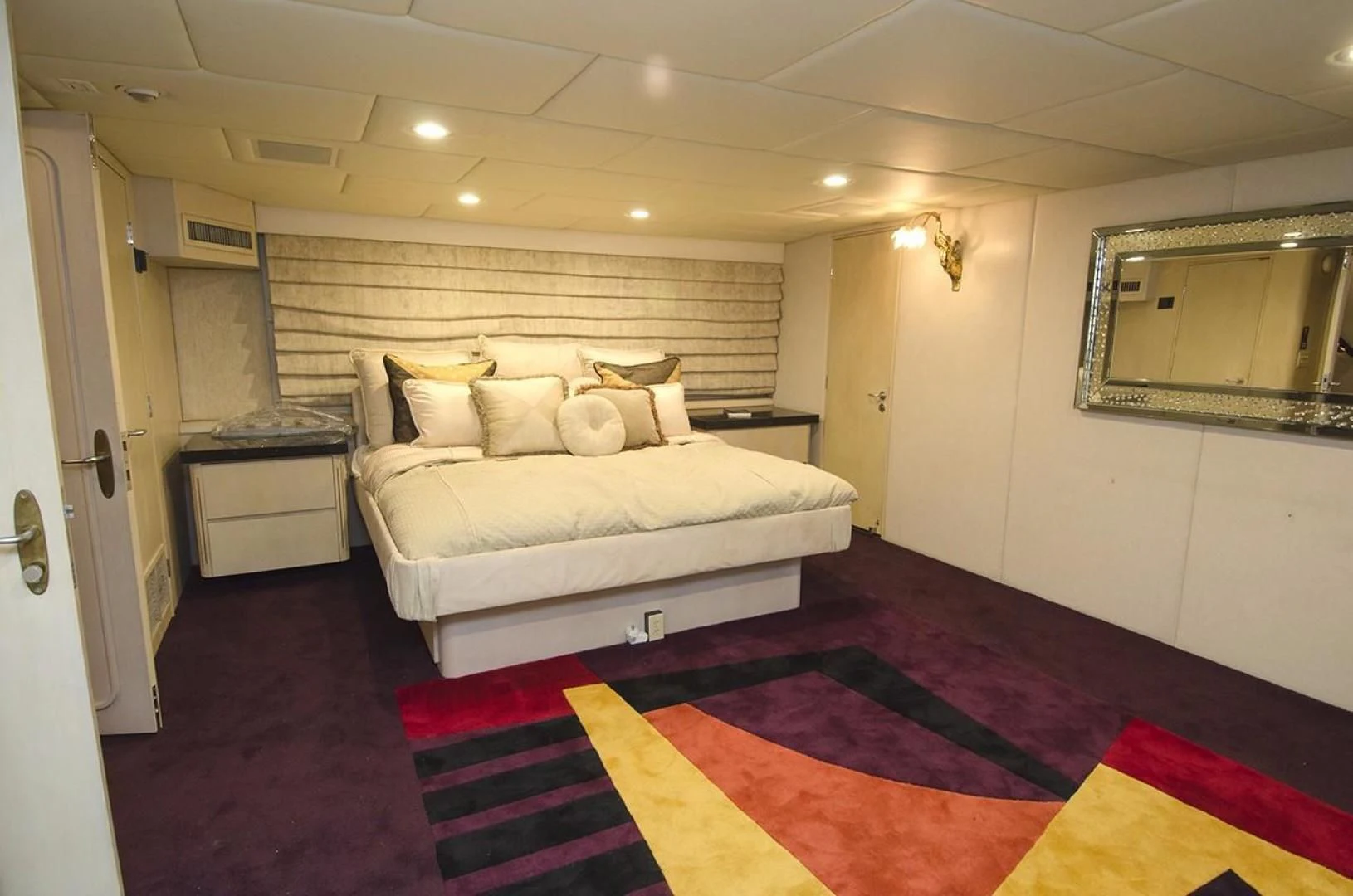 a bedroom with a bed and a red rug aboard GOLDEN TOUCH Yacht for Sale