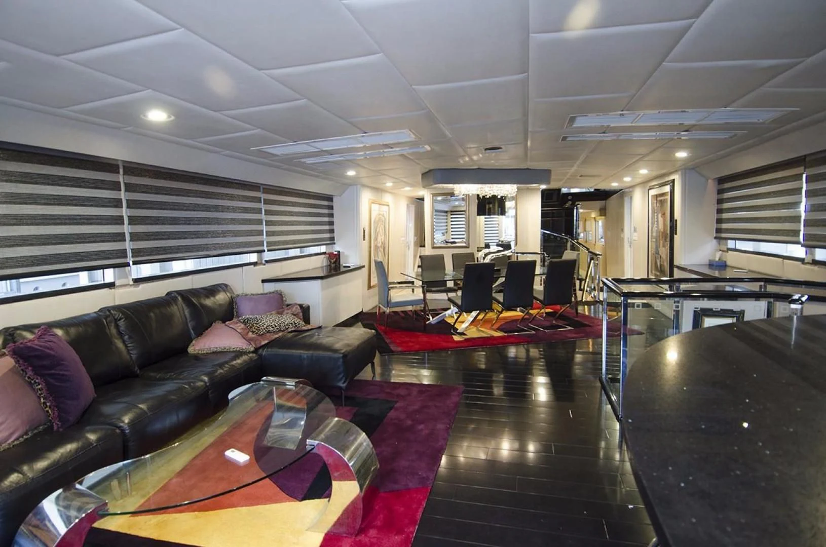 a large living room with a large black table and black couches aboard GOLDEN TOUCH Yacht for Sale