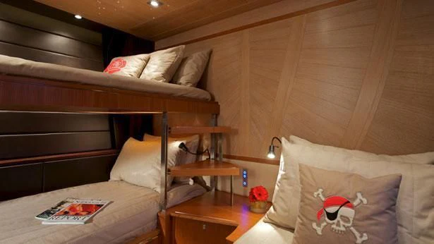 a bed with a wooden headboard aboard SHARLOU Yacht for Sale