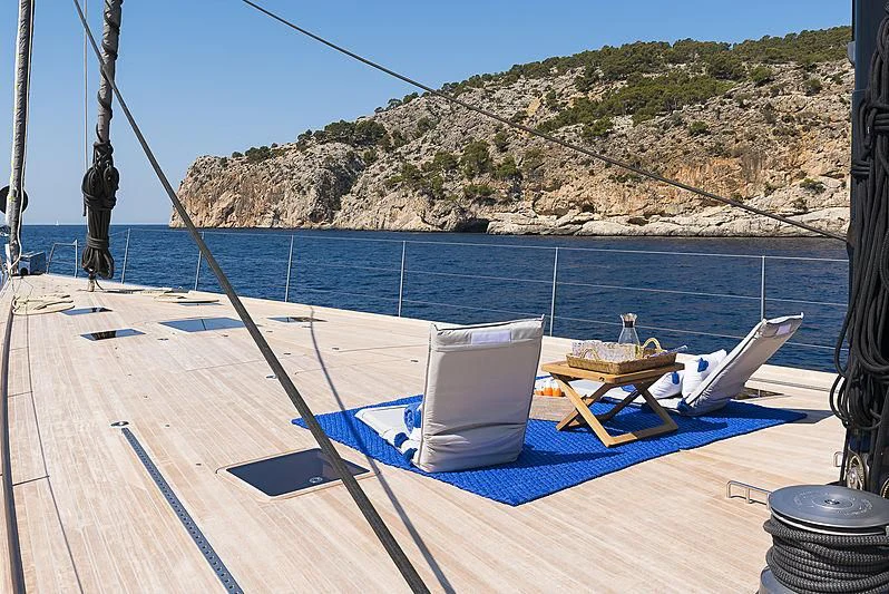 a lounge chair on a deck overlooking a beach aboard SHARLOU Yacht for Sale