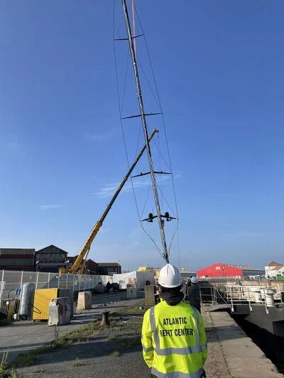 a person wearing a hard hat and a yellow vest standing next to a tall metal pole aboard SHARLOU Yacht for Sale