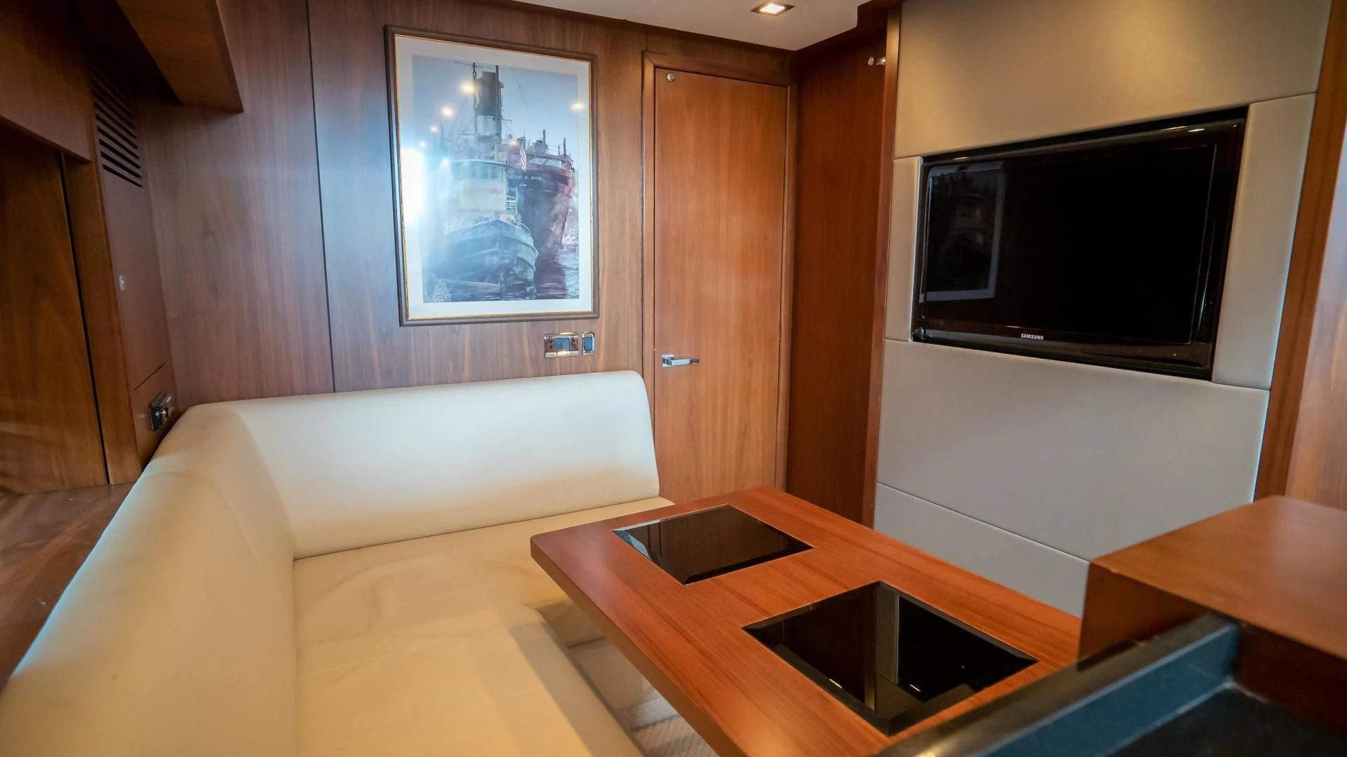 a living room with a tv and a table aboard JIMBO Yacht for Sale