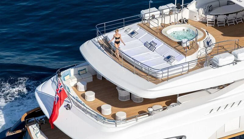 a large white ship with a red flag on the deck aboard MISCHIEF Yacht for Sale