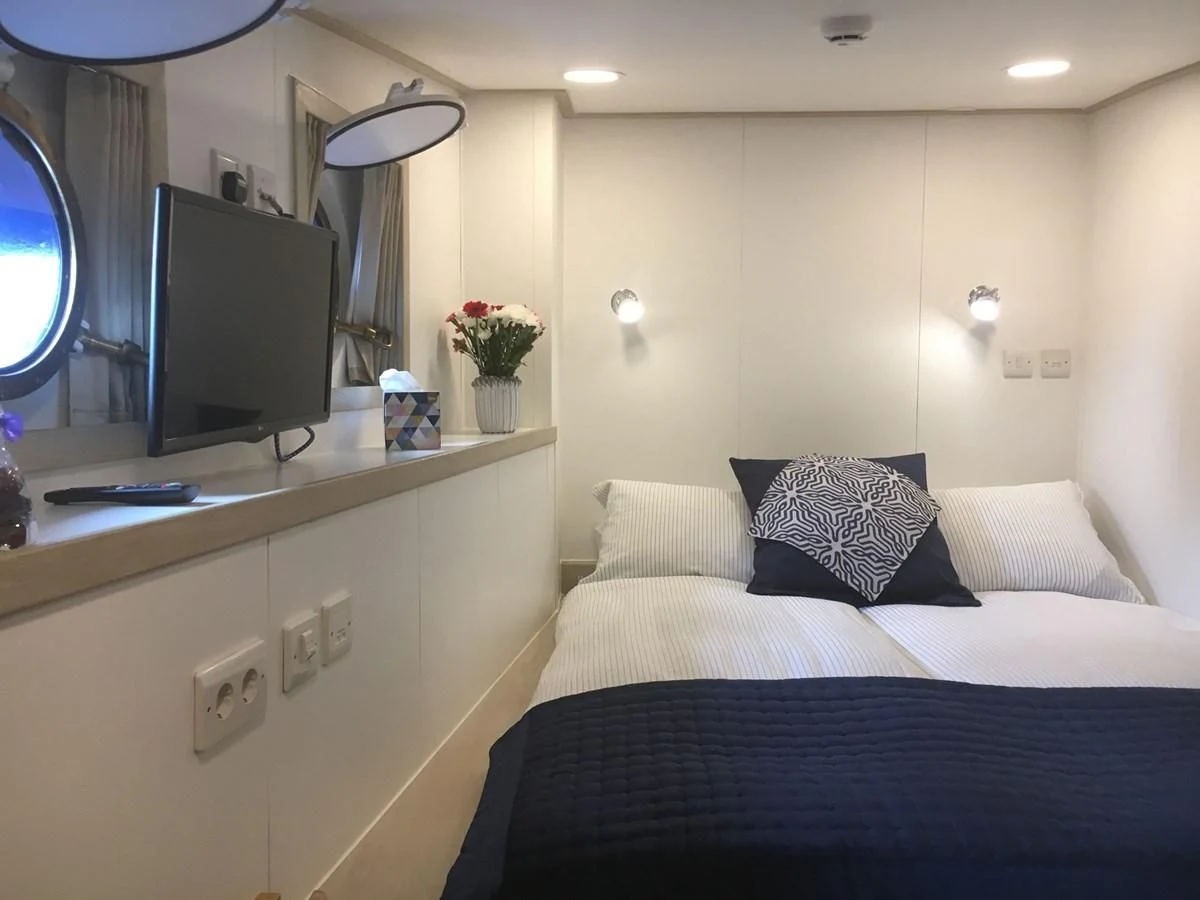 a bed with a blue blanket aboard SPIRIT OF GINETTE Yacht for Sale