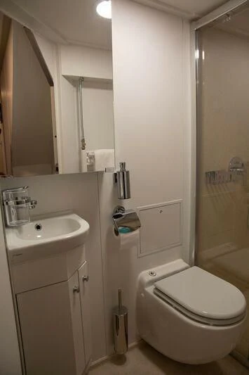 a bathroom with a toilet sink and mirror aboard SPIRIT OF GINETTE Yacht for Sale