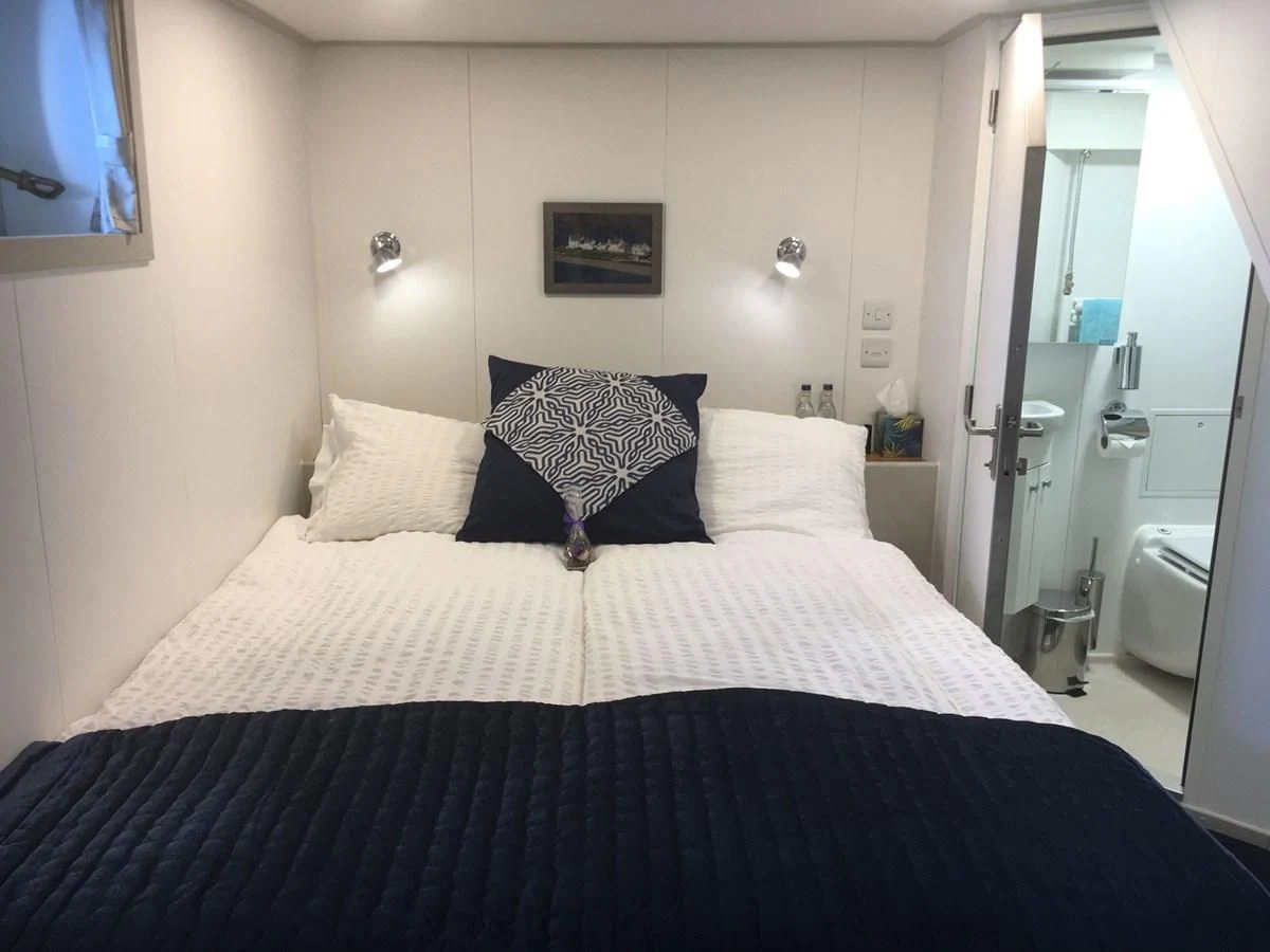 a bed with a black and white blanket on it aboard SPIRIT OF GINETTE Yacht for Sale