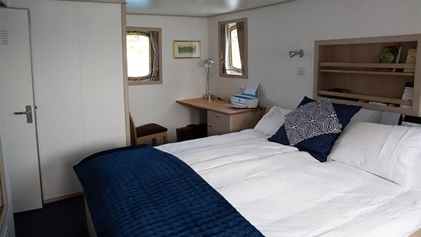 a bedroom with a bed and a desk aboard SPIRIT OF GINETTE Yacht for Sale
