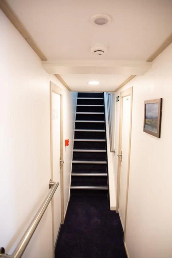 a hallway with a staircase and doors aboard SPIRIT OF GINETTE Yacht for Sale