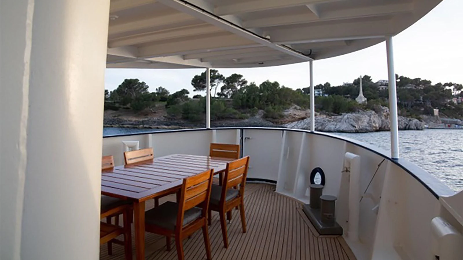 a deck with a table and chairs on it aboard SPIRIT OF GINETTE Yacht for Sale