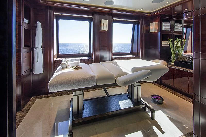 a room with a bed and a table aboard EMINENCE Yacht for Sale