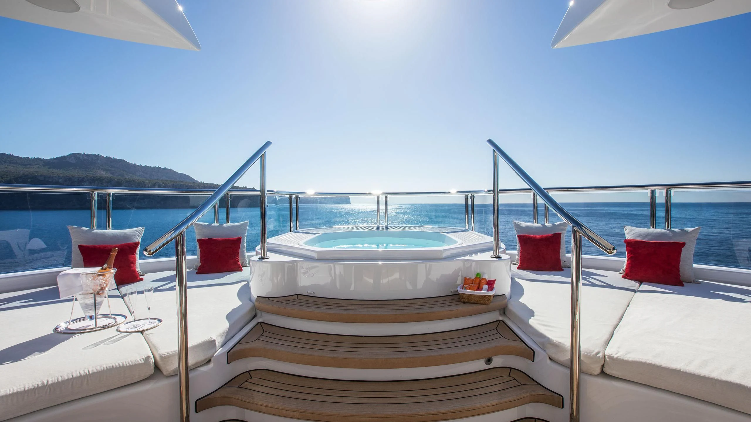 a room with a bed and a table with pillows on it aboard EMINENCE Yacht for Sale