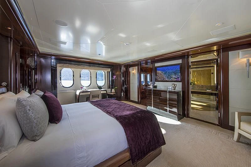 a room with a bed and a large mirror aboard EMINENCE Yacht for Sale