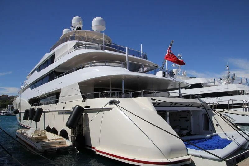 a large white yacht with a red flag on top aboard EMINENCE Yacht for Sale