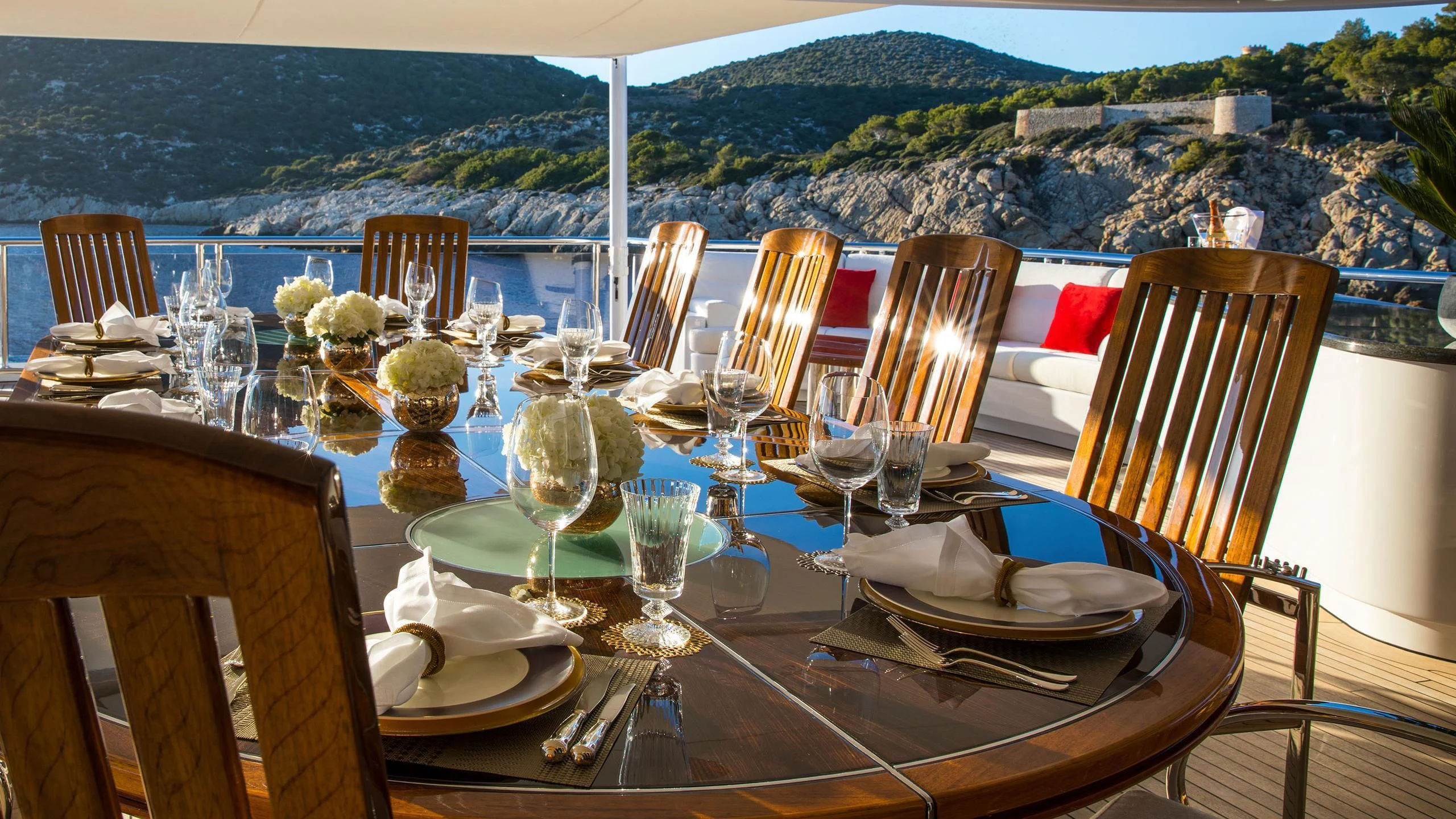 a table set for a dinner on a balcony overlooking a city aboard EMINENCE Yacht for Sale