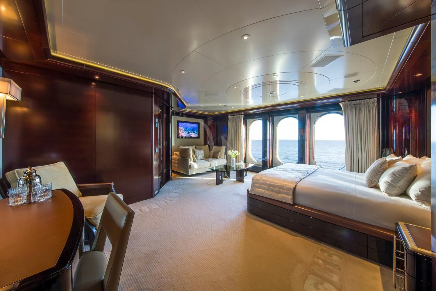 a room with a bed and a table aboard EMINENCE Yacht for Sale