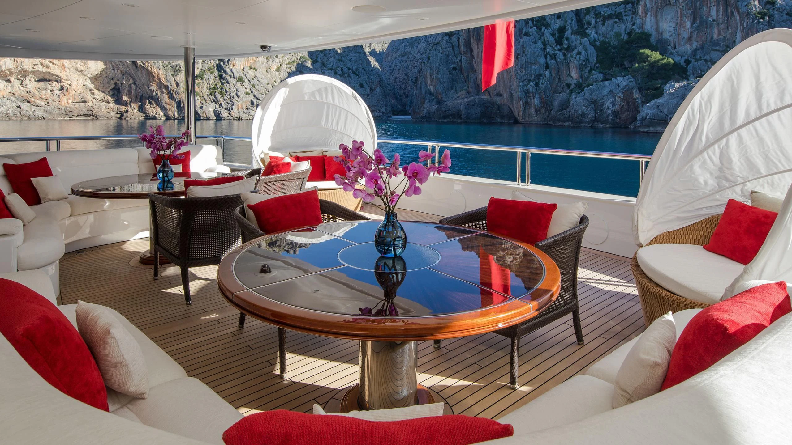 a living room with a large glass table and a large window aboard EMINENCE Yacht for Sale