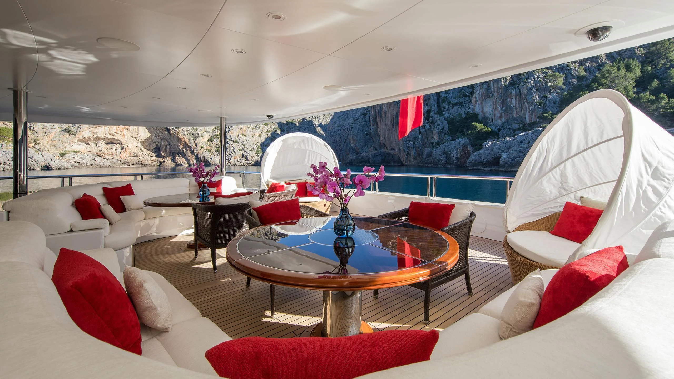 a living room with a large glass table and a large window aboard EMINENCE Yacht for Sale
