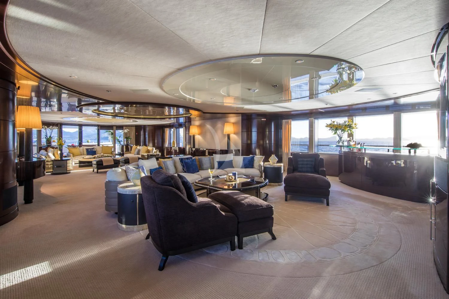 a large living room with a large chandelier aboard EMINENCE Yacht for Sale