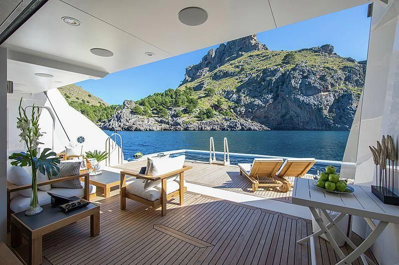 a room with a table chairs and plants on the floor aboard EMINENCE Yacht for Sale