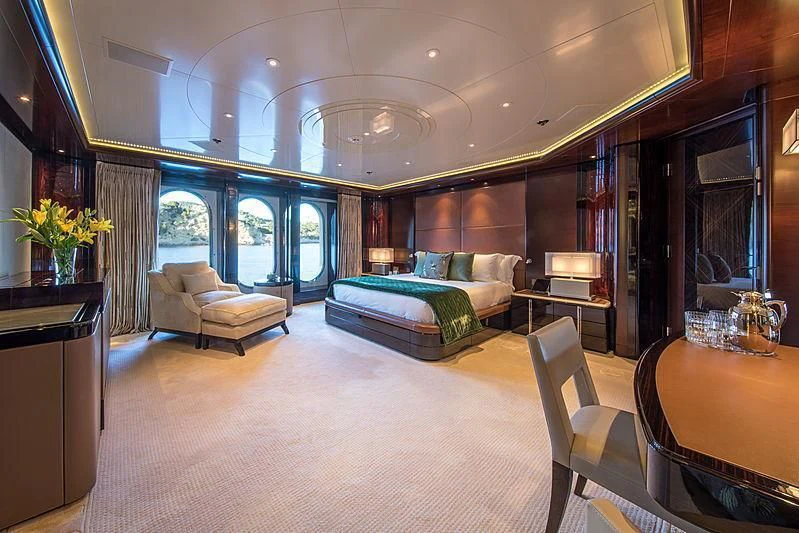 a large room with a bed and a table aboard EMINENCE Yacht for Sale