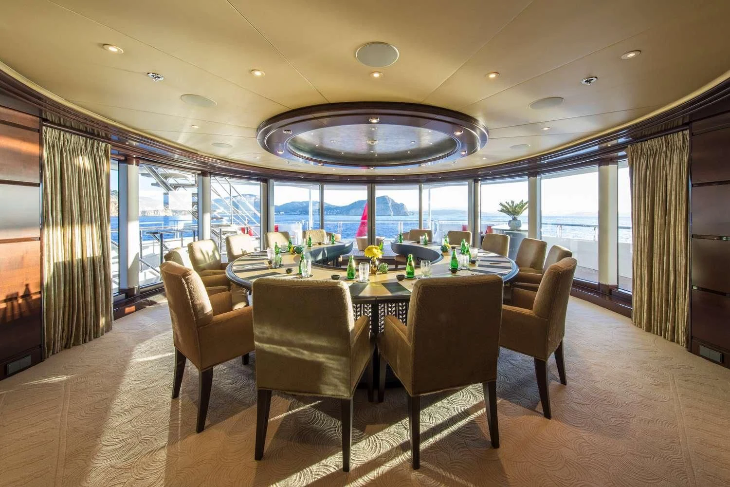 a large room with a table and chairs aboard EMINENCE Yacht for Sale