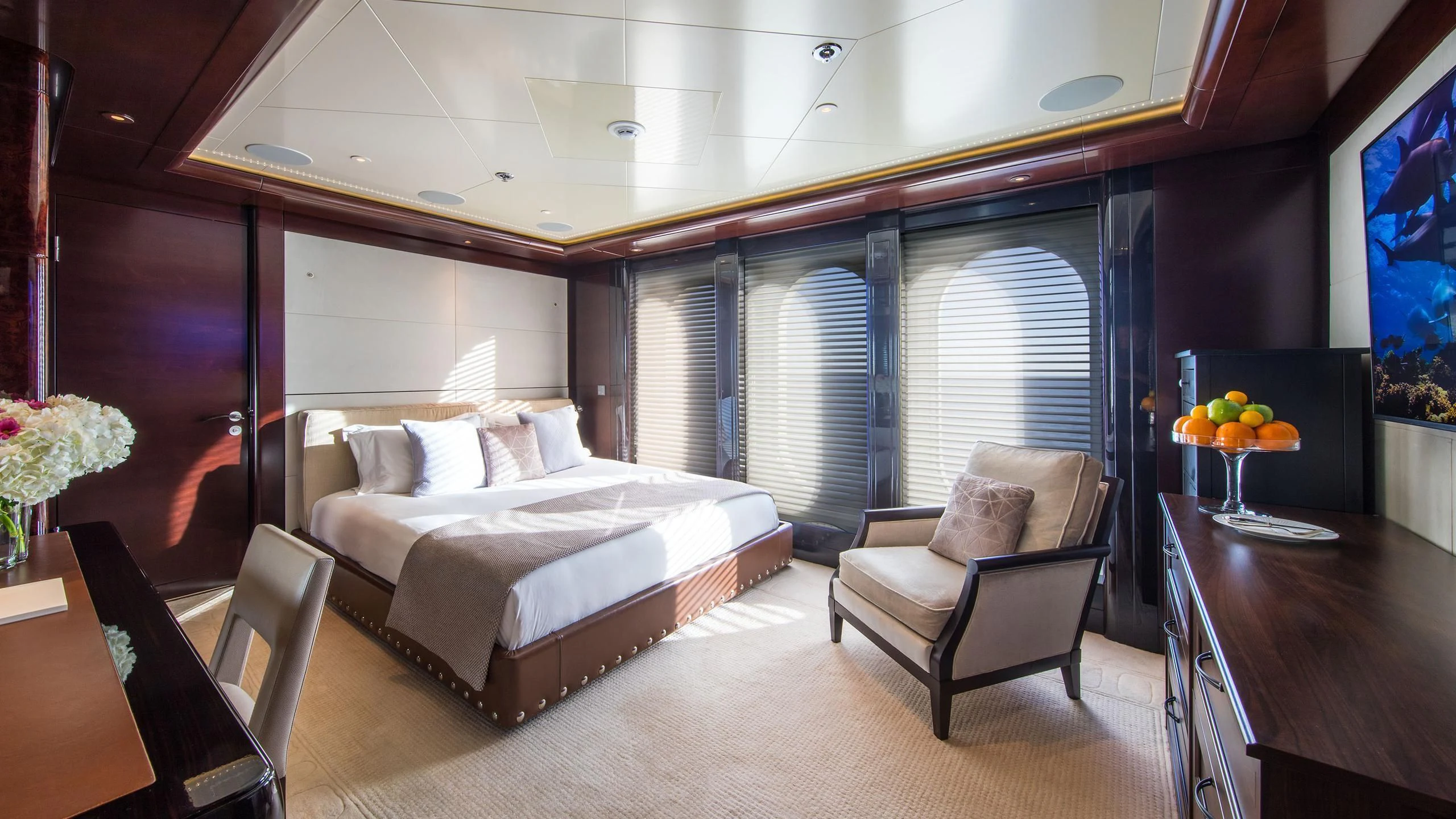 a room with a bed and a chair aboard EMINENCE Yacht for Sale