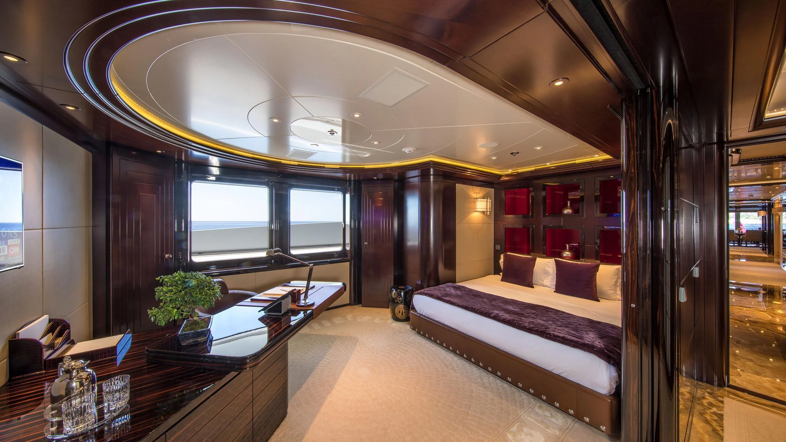a room with a bed and a desk aboard EMINENCE Yacht for Sale