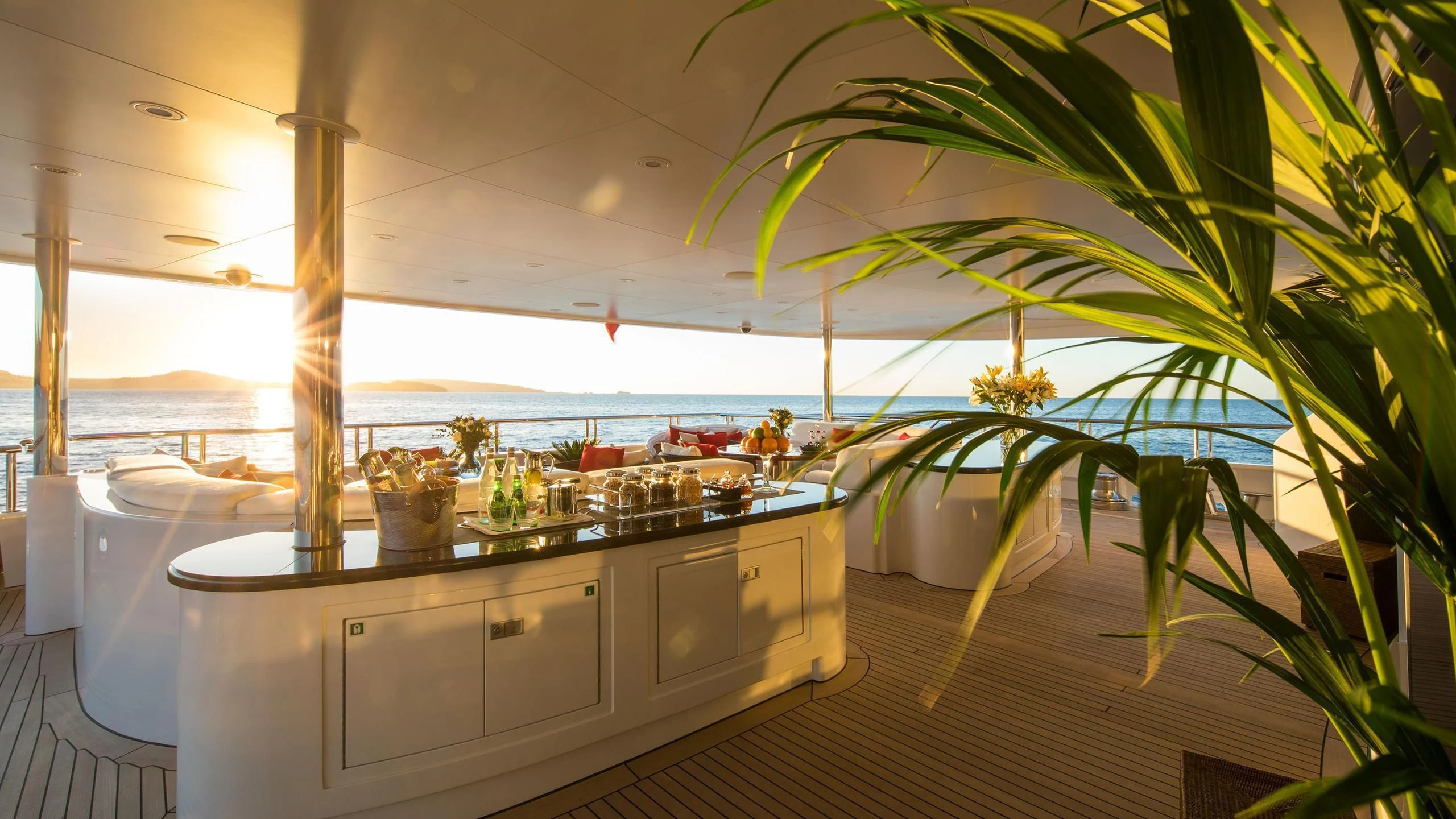 a kitchen with white cabinets and a large window with a plant on the counter aboard EMINENCE Yacht for Sale