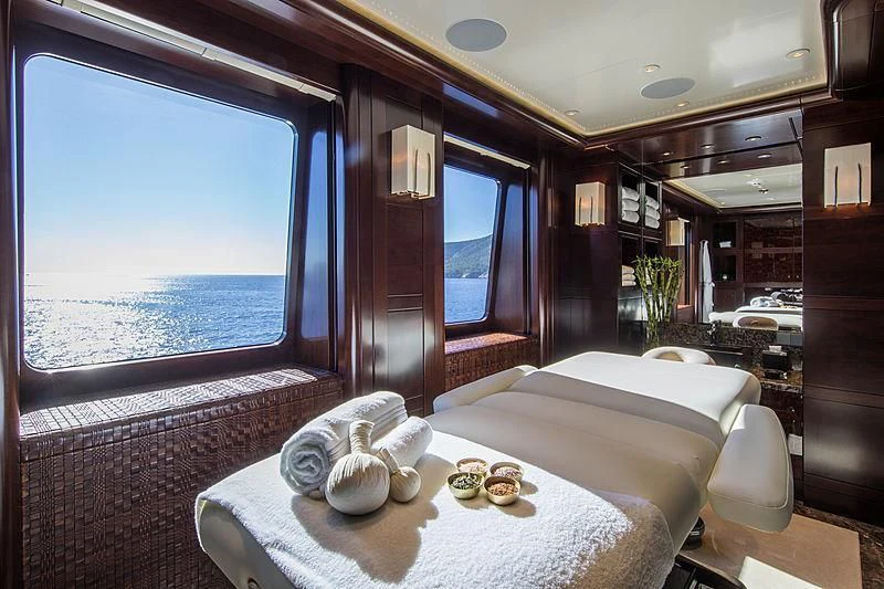 a room with a bed and a table with food on it aboard EMINENCE Yacht for Sale