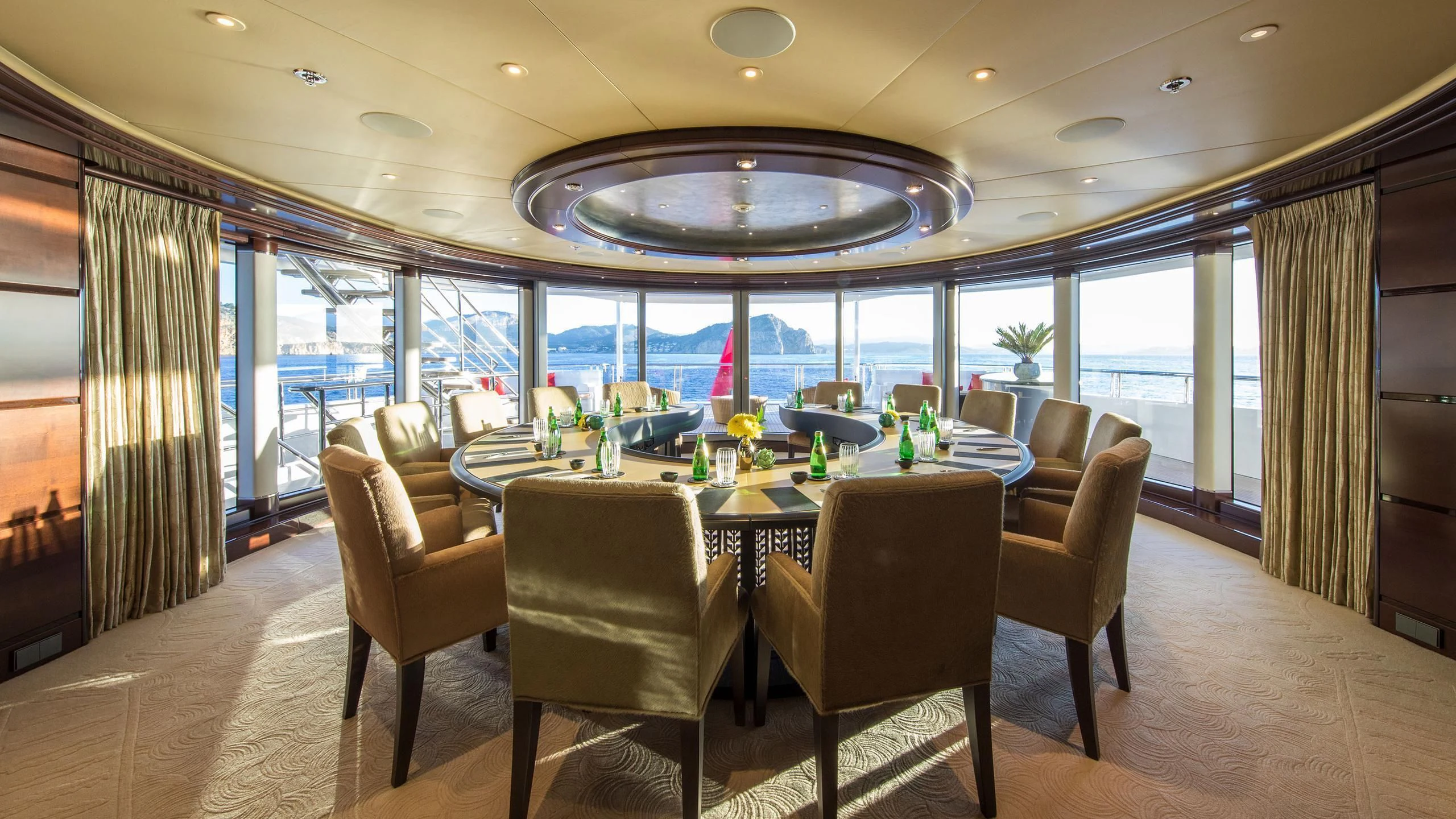 a large room with a table and chairs aboard EMINENCE Yacht for Sale