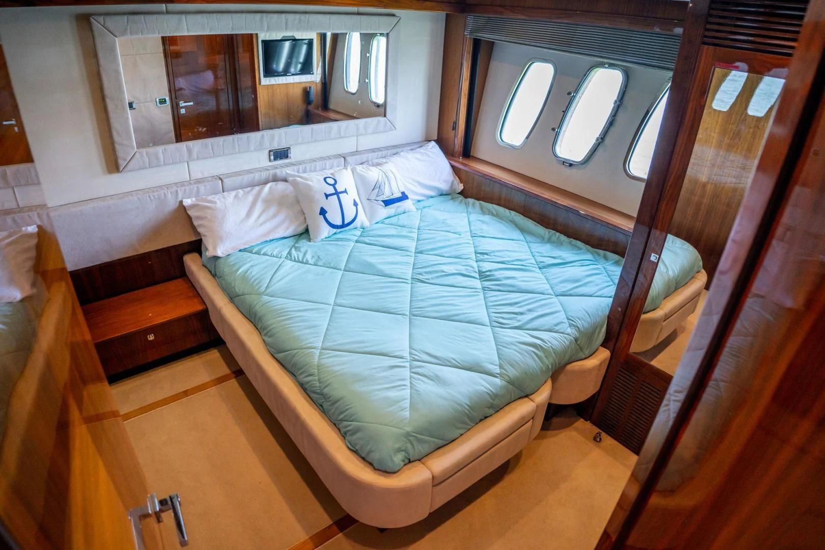 a bed with a blue comforter aboard THE CABANA Yacht for Sale