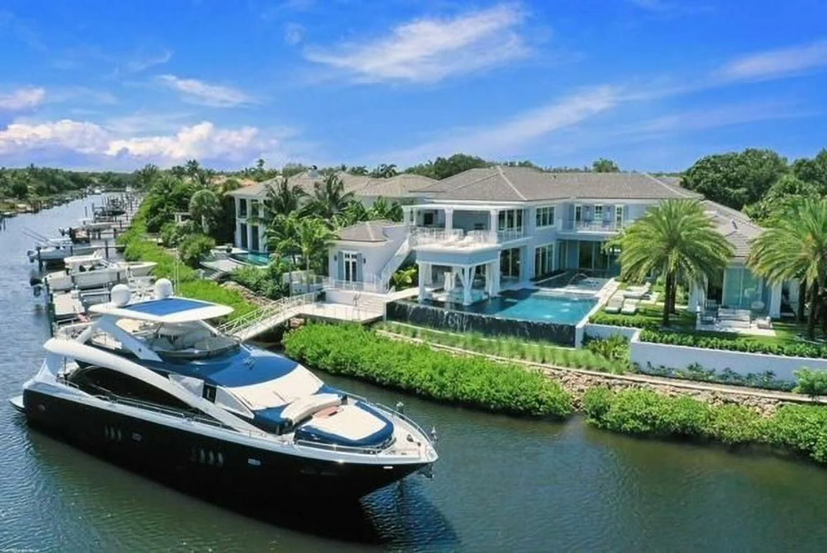 a boat docked in front of a house aboard THE CABANA Yacht for Sale