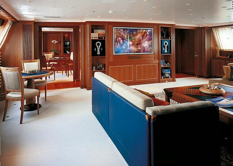 a living room with a blue couch aboard BURRASCA Yacht for Sale