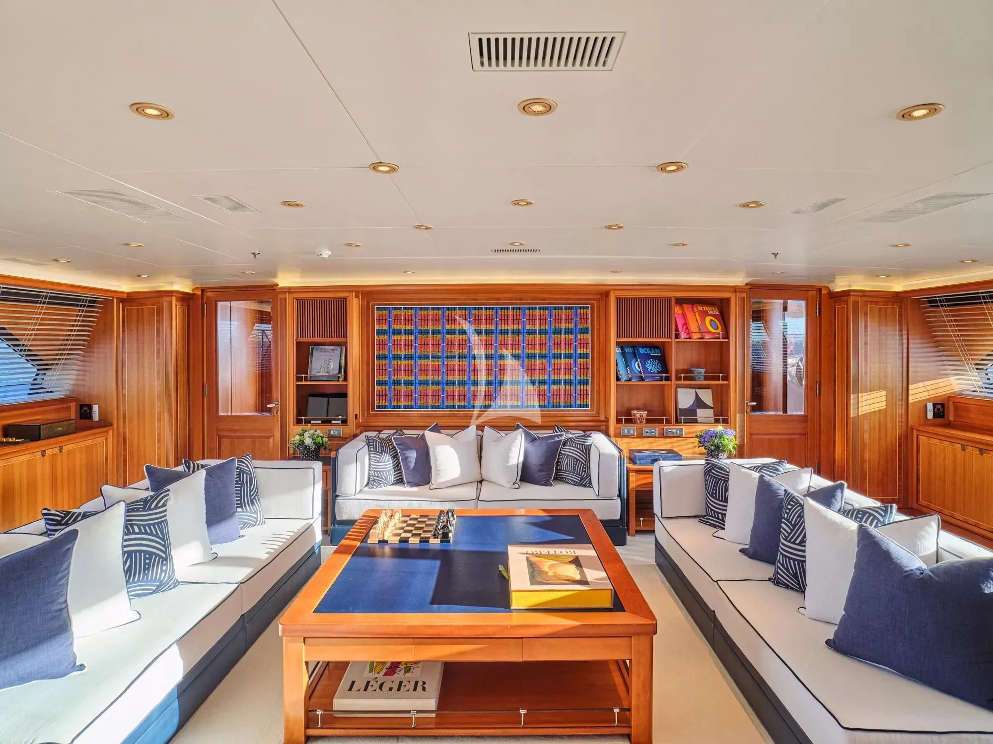 a living room with a table and couches aboard BURRASCA Yacht for Sale