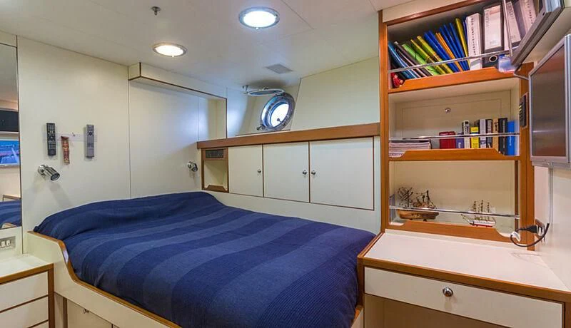 a bedroom with a bookcase and a bed aboard BURRASCA Yacht for Sale