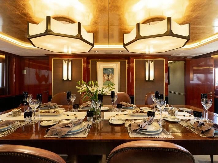 a dining room table with plates and glasses aboard IL SOLE Yacht for Sale