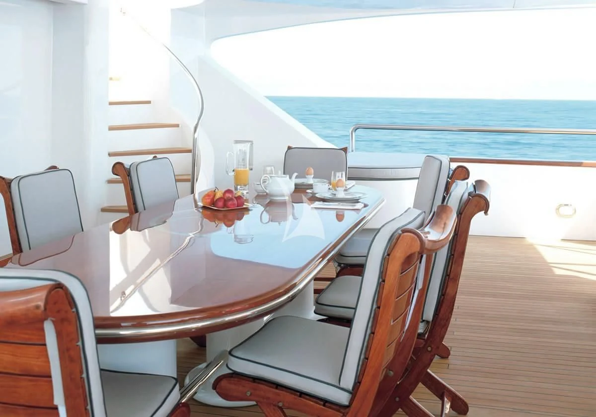 a table with chairs and a glass of beer on it aboard IL SOLE Yacht for Sale