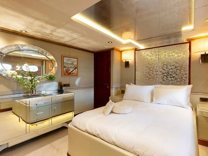 a bedroom with a large mirror above a bed aboard IL SOLE Yacht for Sale