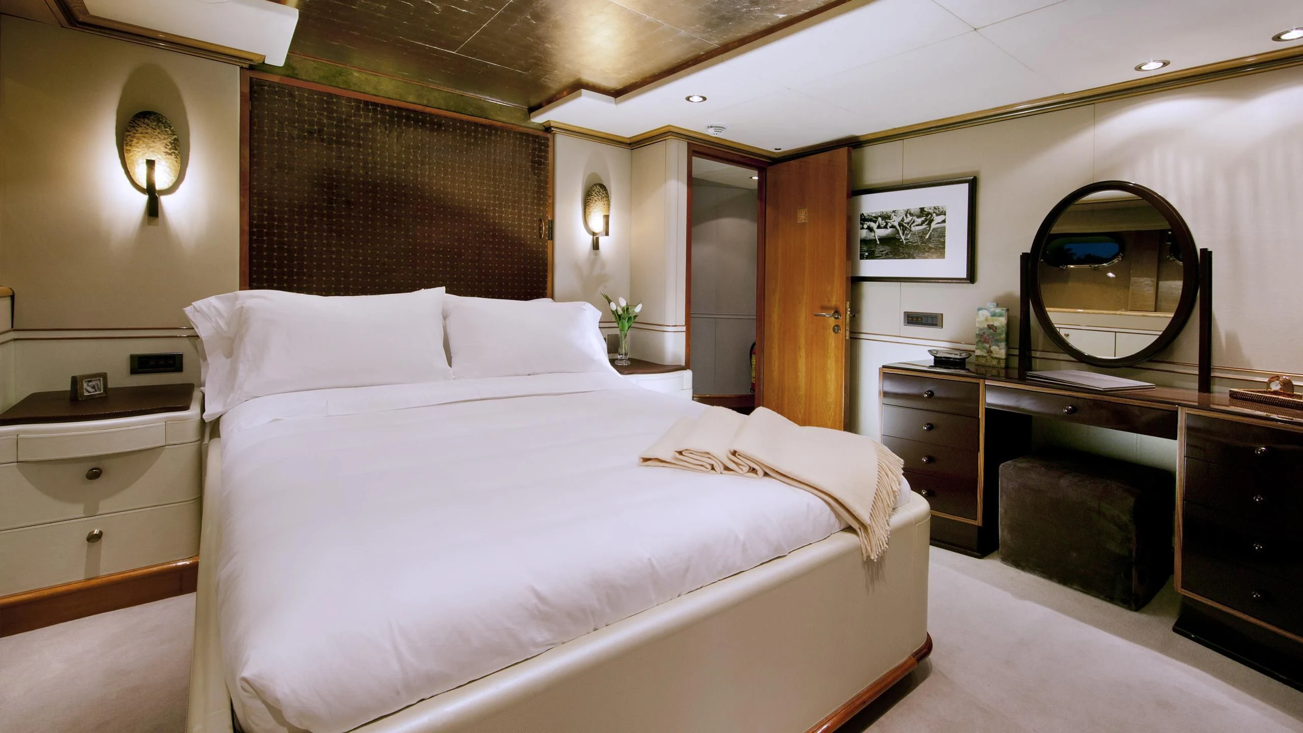 a bedroom with a bed and a dresser aboard IL SOLE Yacht for Sale