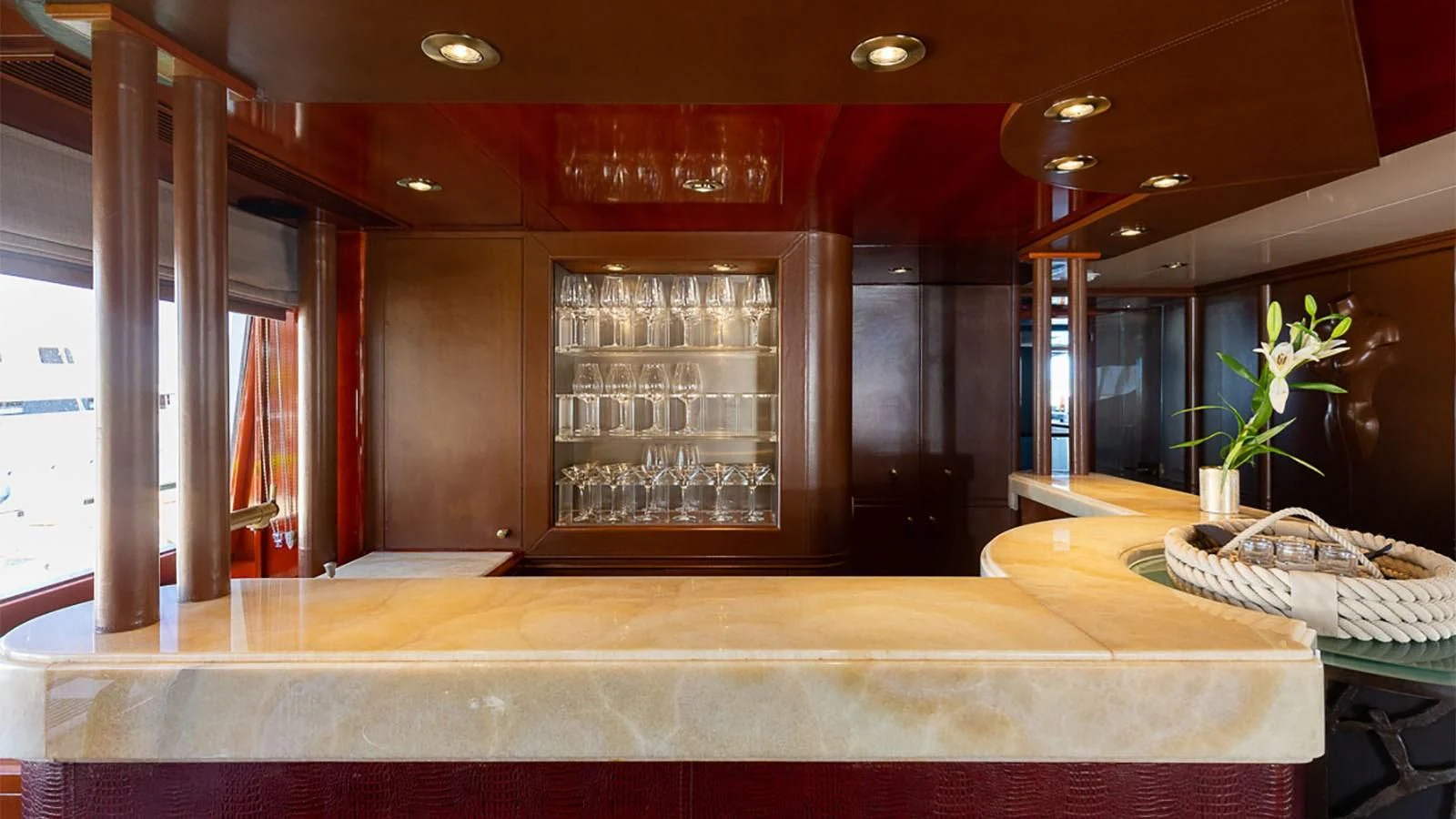 a bar with a table and a vase with flowers in it aboard IL SOLE Yacht for Sale