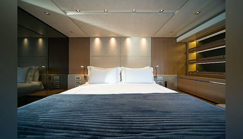 a bed with a blue sheet aboard SQUALO Yacht for Sale