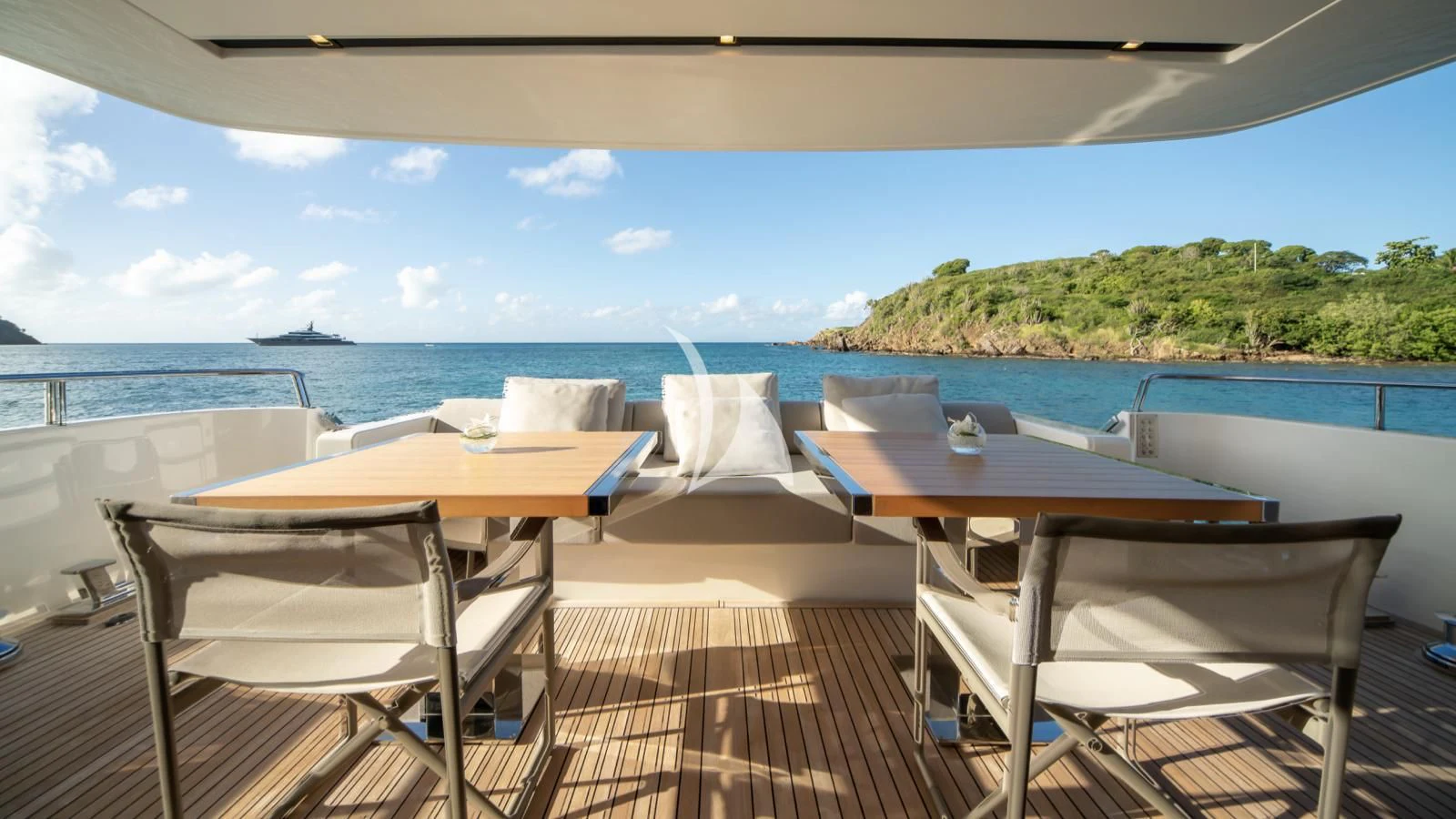 a table and chairs on a deck overlooking a body of water aboard SQUALO Yacht for Sale