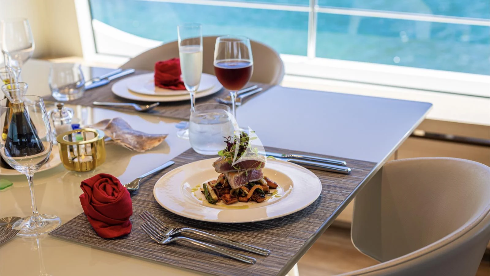a table with plates of food and glasses of wine aboard SQUALO Yacht for Sale