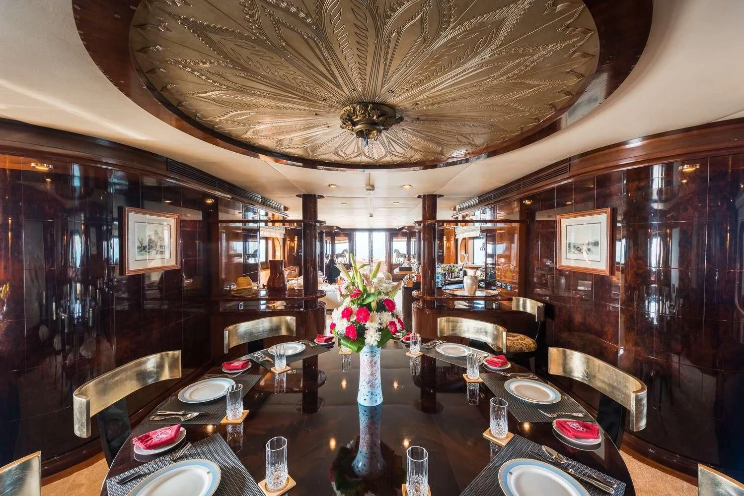 a dining room with a vase of flowers on the table aboard ASHENA Yacht for Charter